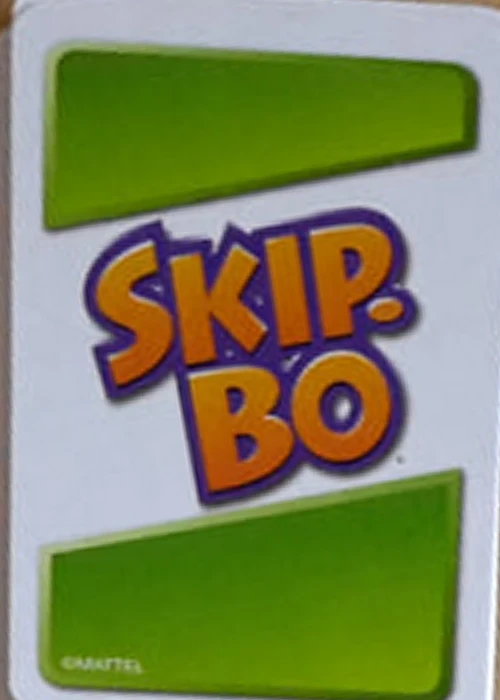 Modern Skip-Bo card back with white center, green panels, and orange logo